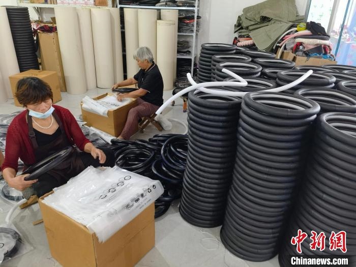 圖為村民在汽車飾品企業(yè)生產(chǎn)車間中工作?！巫雍?攝