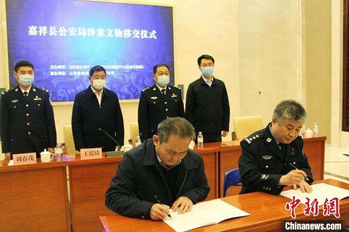 山東博物館館長鄭同修和嘉祥縣人民政府副縣長、公安局局長趙健簽署移交協(xié)議。　趙曉 攝