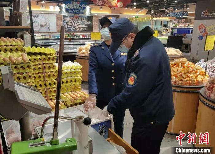 圖為疫情期間，甘肅嘉峪關(guān)市場監(jiān)管局工作人員檢查蔬菜市場?！?柴佳楠 　攝