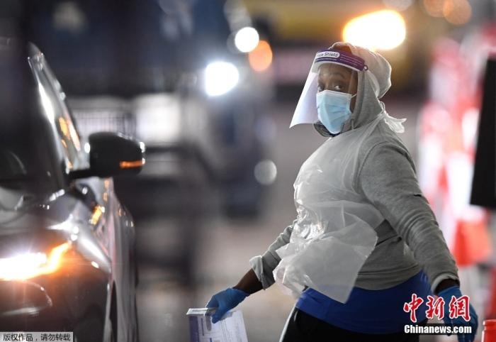 當(dāng)?shù)貢r間12月18日，英國政府公布的數(shù)據(jù)顯示，當(dāng)天英國新增奧密克戎毒株感染病例10059例。鑒于奧密克戎毒株感染病例激增，住院人數(shù)不斷上升，倫敦市長宣布倫敦進(jìn)入“重大事故”狀態(tài)。圖為倫敦的一個免下車檢測中心，一名醫(yī)務(wù)工作者正準(zhǔn)備對司機(jī)進(jìn)行核酸檢測。