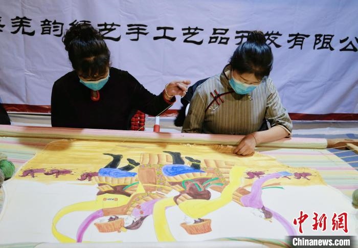 圖為皮繡藝人在市集上“秀”指尖技藝?！●R銘言 攝