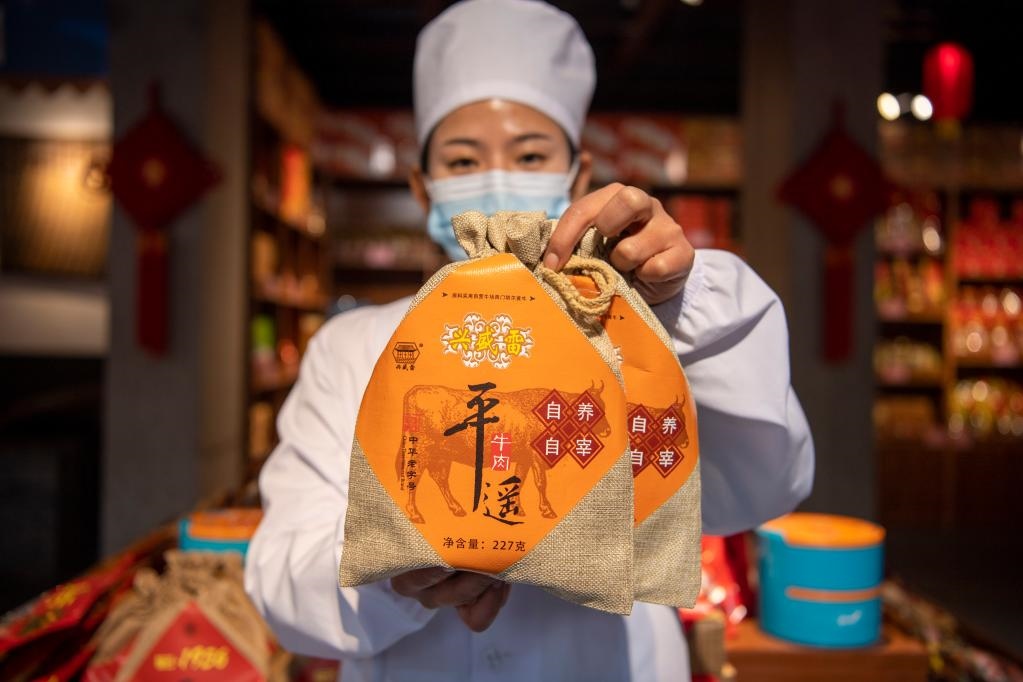 1月27日，在平遙古城南大街的一家平遙牛肉店內(nèi)，工作人員展示一款牛肉產(chǎn)品。新華社記者 楊晨光 攝