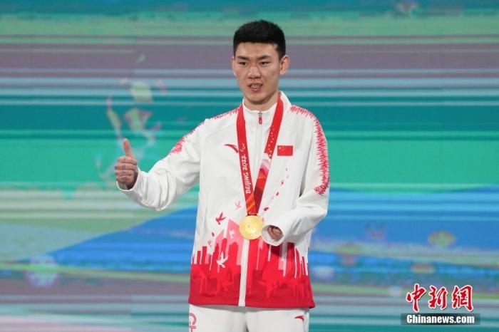 3月6日，梁景怡在延慶頒獎(jiǎng)廣場(chǎng)領(lǐng)獎(jiǎng)臺(tái)上豎起大拇指。當(dāng)日，在國(guó)家高山滑雪中心舉行的北京2022年冬殘奧會(huì)殘奧高山滑雪男子超級(jí)大回轉(zhuǎn)—站姿決賽中，中國(guó)選手梁景怡奪得冠軍。 <a target='_blank' href='/'>中新社</a>記者 楊華峰 攝