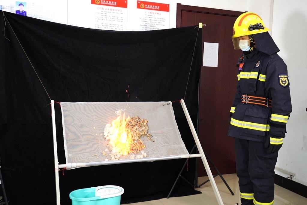 消防員在展示柳絮點燃實驗。 張少欣 攝