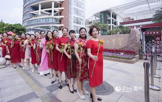 6月7日一早，廈門雙十中學(xué)考生家長們身穿旗袍，手拿向日葵在考場外為孩子加油打氣，寓意“旗開得勝，一舉奪魁”。人民網(wǎng)記者 陳博攝