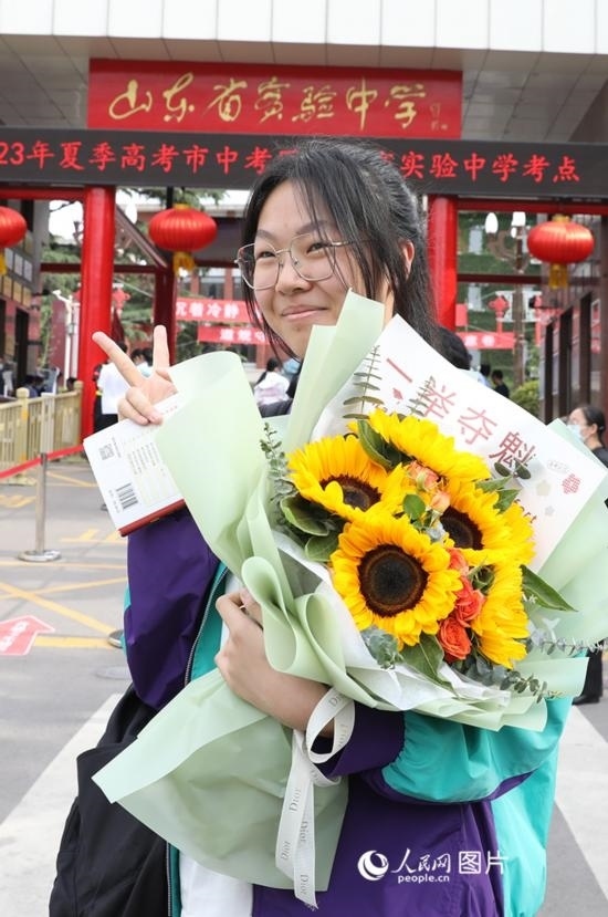 6月7日高考首日，山東67萬考生走進考場，拼搏逐夢。在山東省實驗中學(xué)考點，考生進考場前手捧向日葵花拍照留念，寓意“一舉奪魁”。人民網(wǎng)記者 劉祺攝