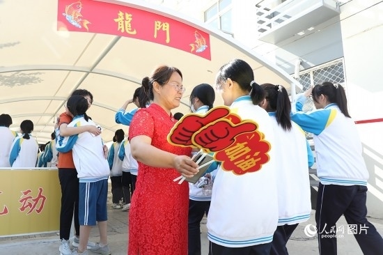 6月7日一早，雄安新區(qū)安新中學(xué)老師在給同學(xué)們加油鼓勁兒。人民網(wǎng) 李兆民攝