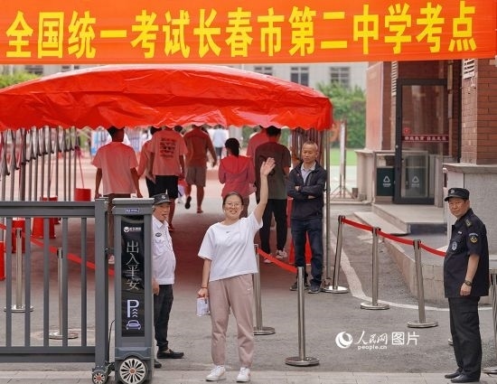 6月7日，在長春市第二中學(xué)考點，一名考生信心滿滿進入考場，并與家長揮手致意。人民網(wǎng)記者 李洋攝