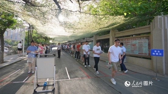 6月7日，烏魯木齊市第七十中學(xué)門口，考生們有序進入考場。人民網(wǎng) 李欣洋攝
