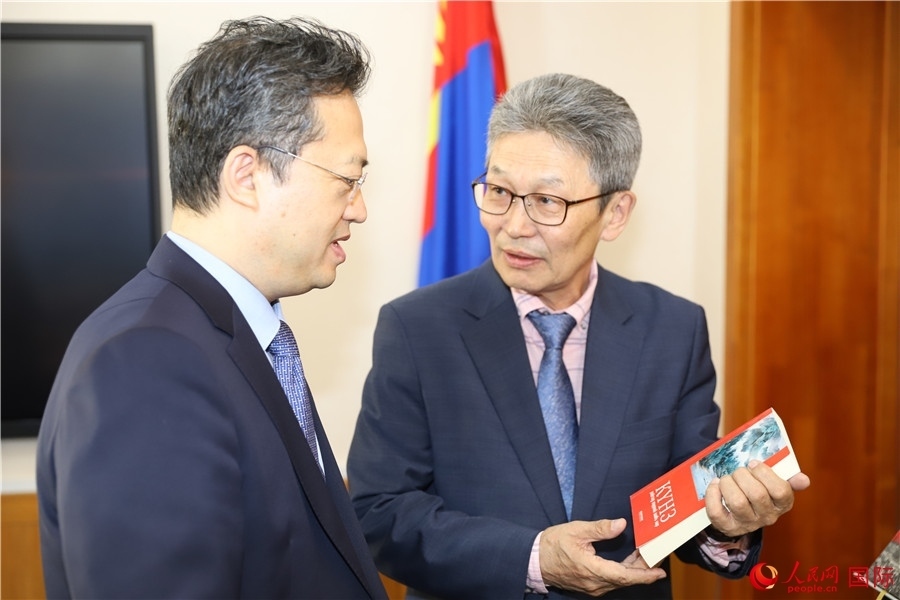 其米德策耶（右一）向李峙介紹翻譯成果。人民網(wǎng)記者 霍文攝