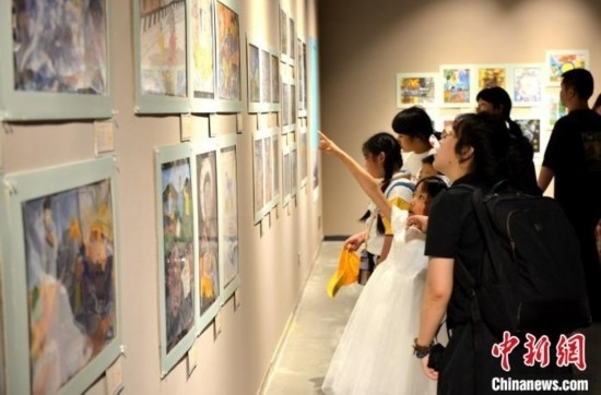 圖為家長帶著孩子參觀展覽。呂明 攝