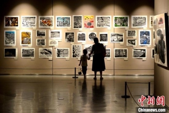 圖為家長帶著孩子參觀展覽。呂明 攝