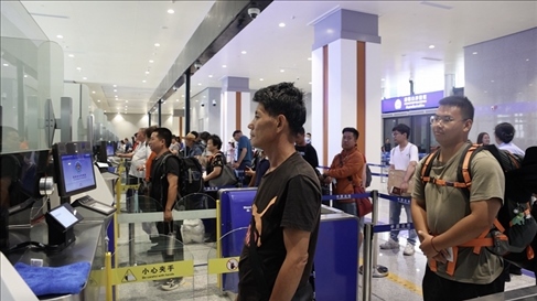 6月13日，乘坐中老鐵路國際旅客列車的旅客在磨憨邊檢大廳排隊(duì)候檢。李揚(yáng) 攝