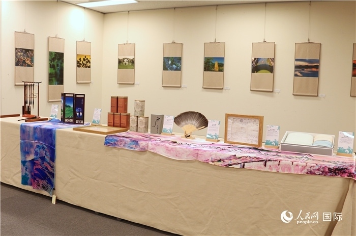 現(xiàn)場展出的馮學(xué)敏攝影作品與湖州市特色工藝品。（人民網(wǎng) 許可攝）