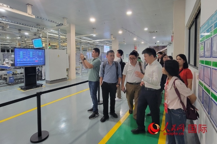 廣汽埃安工作人員向外媒記者進(jìn)行介紹。人民網(wǎng) 寧玉瑛攝