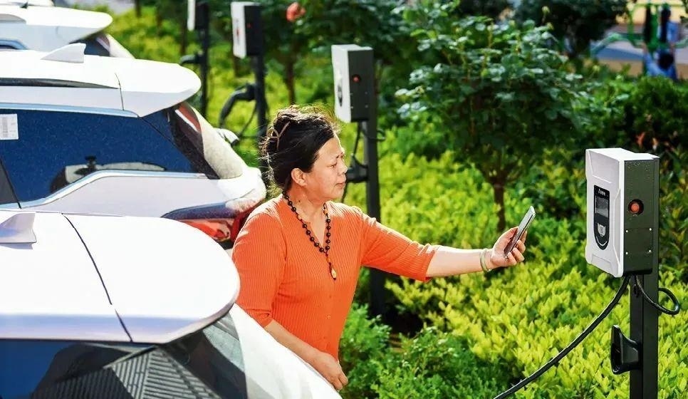 2023年5月24日，山東省膠州市新立街小區(qū)內(nèi)一位居民使用電動(dòng)汽車充電樁掃碼充電。該小區(qū)加裝各類智慧設(shè)備，打造“智慧社區(qū)”，為居民生活帶來(lái)便利。