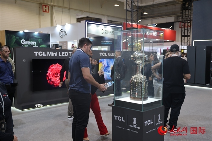 參觀者在TCL展臺前觀看南美解放者杯獎(jiǎng)杯，據(jù)介紹，TCL是南美解放者杯（2023—2026賽季）全球官方合作伙伴。（人民網(wǎng)記者 時(shí)元皓攝）