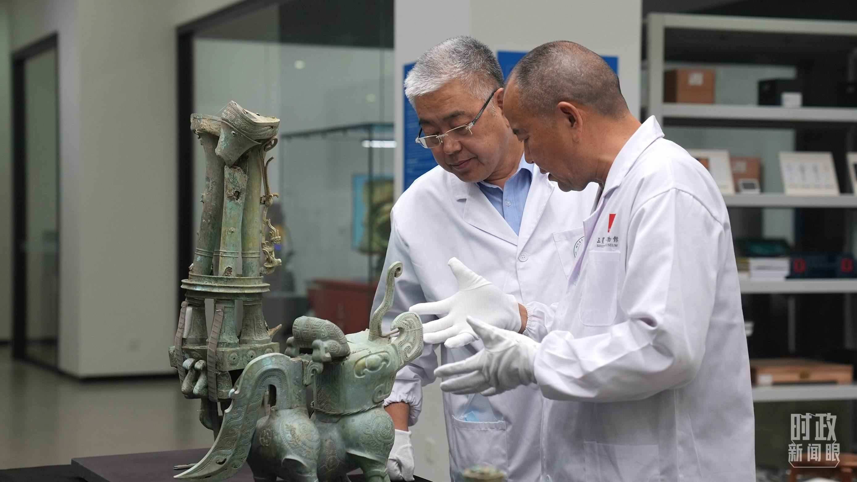 △三星堆文保專家正在就修復(fù)方案進行討論。（總臺央視記者劉琦拍攝）