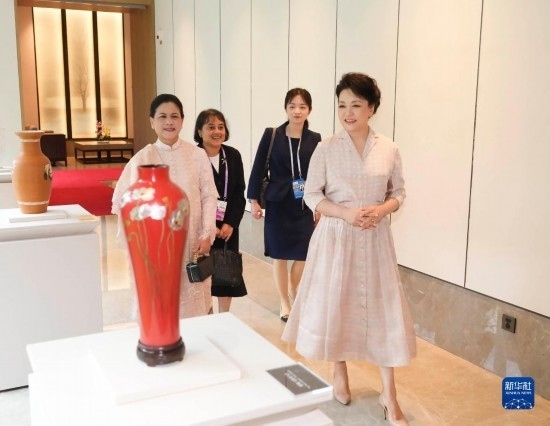 7月27日下午，國家主席習(xí)近平夫人彭麗媛在四川成都會見陪同印度尼西亞總統(tǒng)佐科來華出席第31屆世界大學(xué)生夏季運(yùn)動會開幕式并訪華的總統(tǒng)夫人伊莉亞娜。這是彭麗媛和伊莉亞娜欣賞成都特色非遺工藝品。新華社記者 丁林 攝