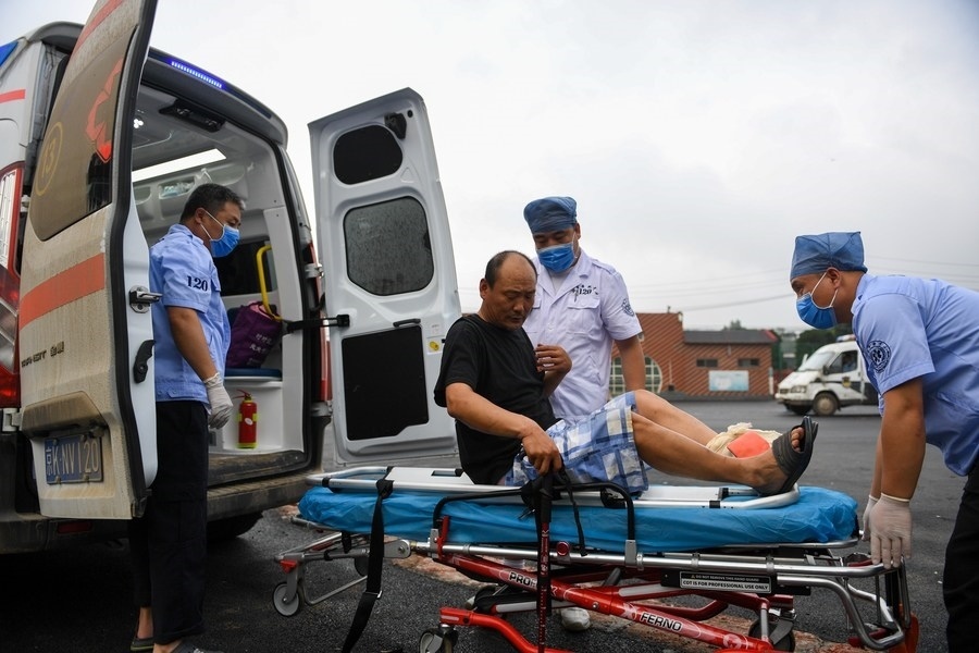 8月1日，在北京市門(mén)頭溝區(qū)妙峰山鎮(zhèn)妙峰山民族學(xué)校臨時(shí)安置點(diǎn)，北京急救中心工作人員在轉(zhuǎn)運(yùn)一名受傷村民。新華社記者 鞠煥宗 攝