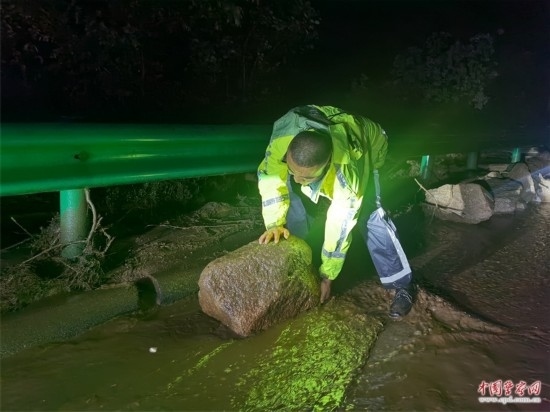 7月31日，張涿高速，高速交警涿鹿大隊民警清理山體滑坡路面落石。
