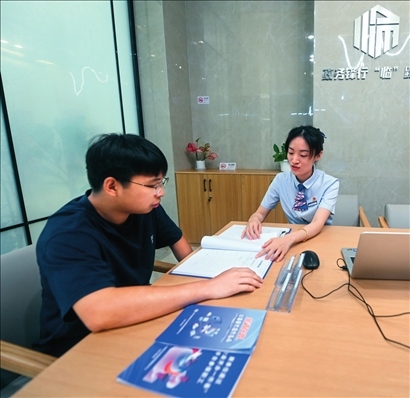 在杭州市臨安區(qū)政務(wù)服務(wù)中心的“為企服務(wù)中心”，黨員志愿者（右）解答企業(yè)主的疑問（2023年7月7日攝）。徐昱攝/本刊