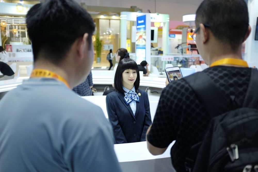 9月1日，媒體記者在國家會議中心與服務(wù)機器人互動。新華社記者 劉夢琪 攝