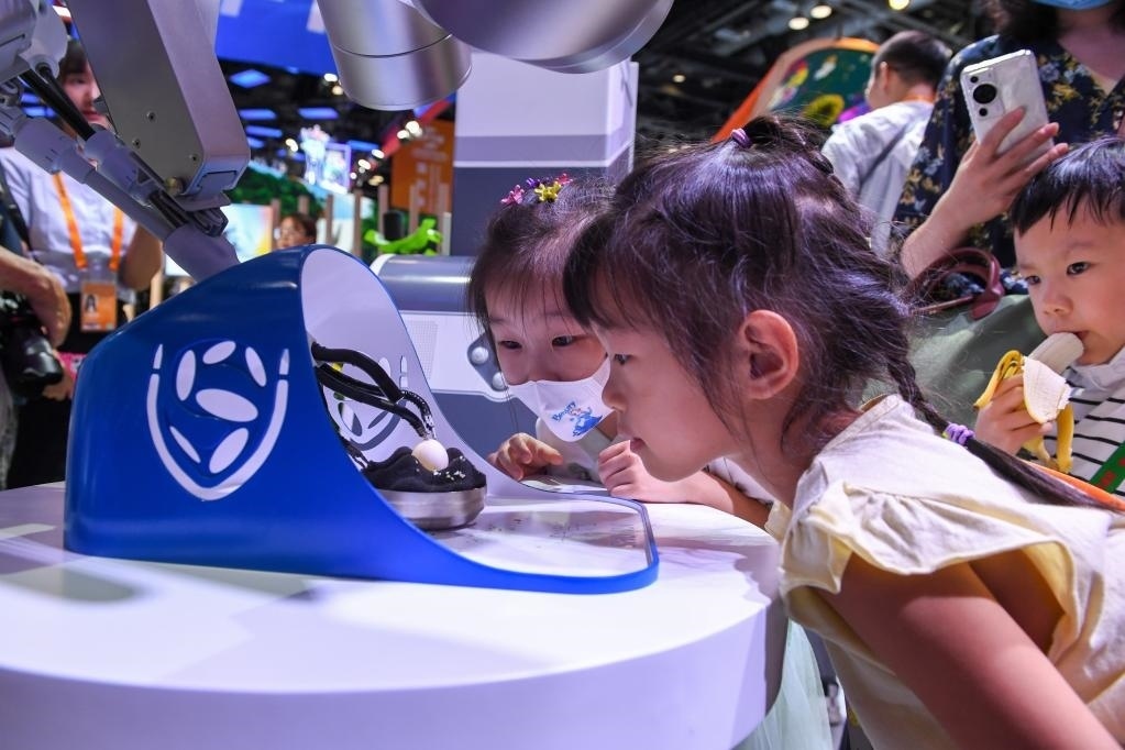 9月3日，幾名小朋友在國家會議中心觀看單孔腔鏡手術(shù)機器人展示。新華社記者 鞠煥宗 攝