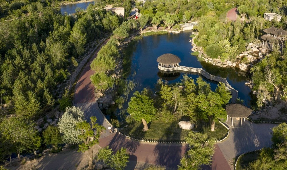 坐落在寧夏銀川市賀蘭山腳下的賀蘭山運(yùn)動(dòng)休閑公園（2021年5月27日攝，無(wú)人機(jī)照片）。這里曾是一片砂石采礦塌陷區(qū)，當(dāng)?shù)赝ㄟ^(guò)植被景觀再造、水系建設(shè)、現(xiàn)代管網(wǎng)鋪建等手段，重新利用廢石、廢坑及各類廢棄建筑材料，把這里變成一座免費(fèi)開放的主題公園。新華社記者 馮開華 攝