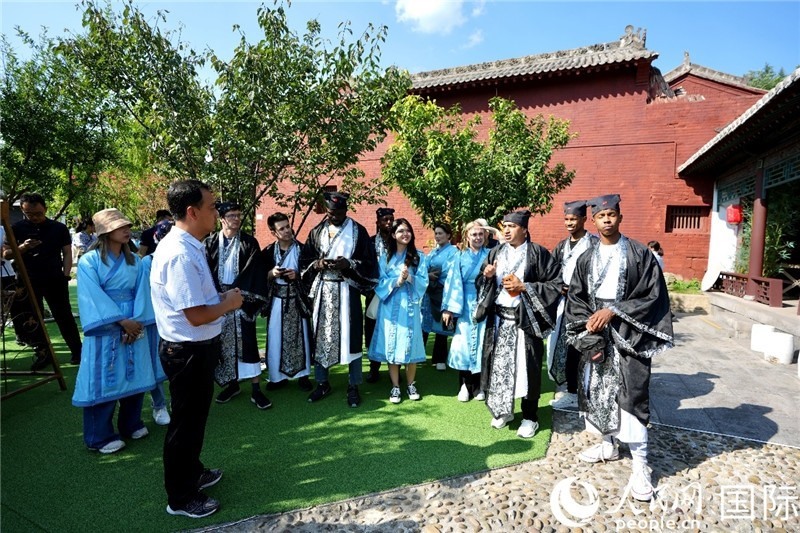 圖為選手們聽導(dǎo)游講解。人民網(wǎng) 盧鵬宇攝