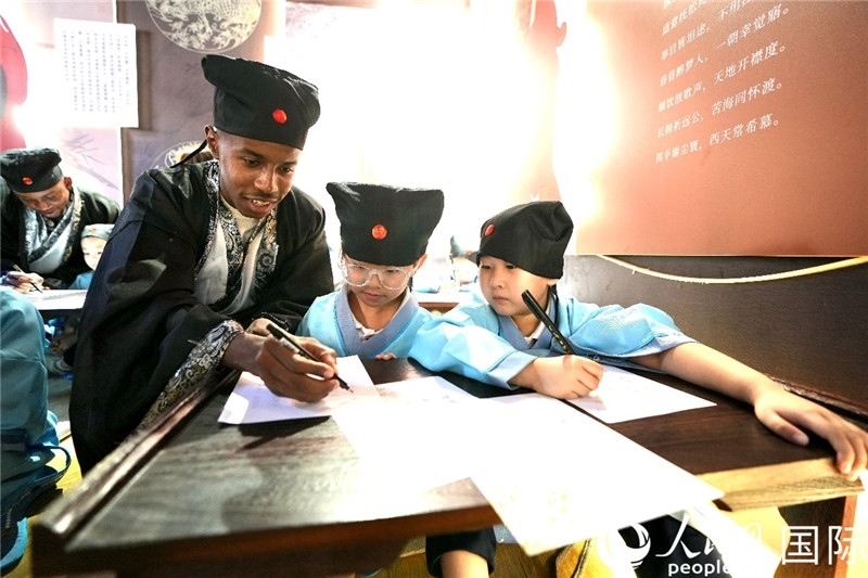 圖為選手與同學(xué)們一起寫書法。人民網(wǎng) 盧鵬宇攝