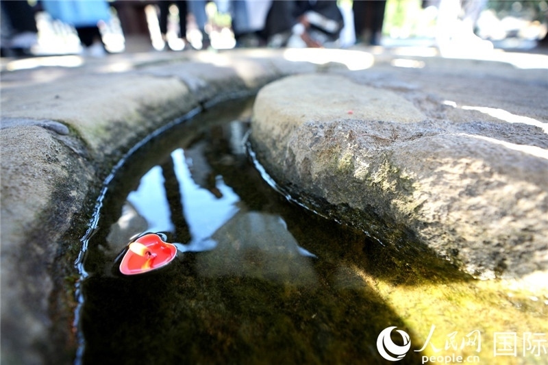 圖為水渠里流過的“桃心”蠟燭。人民網(wǎng) 盧鵬宇攝