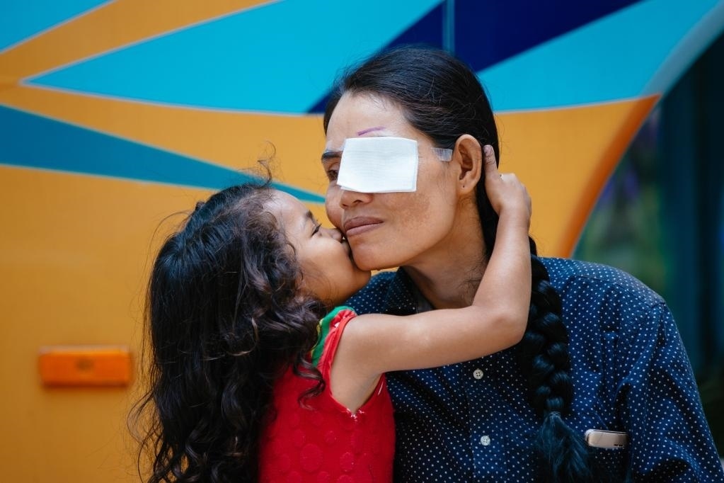 2019年3月15日，在柬埔寨磅湛省醫(yī)院，即將接受白內(nèi)障手術(shù)的患者孫美樂接受女兒的親吻祝福。在接受了中國醫(yī)療隊(duì)的白內(nèi)障義診手術(shù)后，她的視力逐步恢復(fù)，生活有了新的光明和希望。