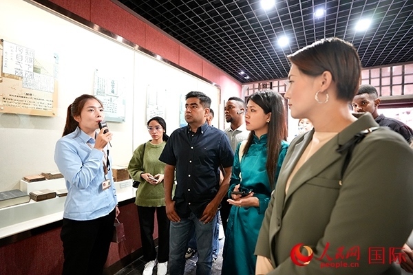 選手們認真聆聽導游講解。人民網(wǎng) 盧鵬宇攝