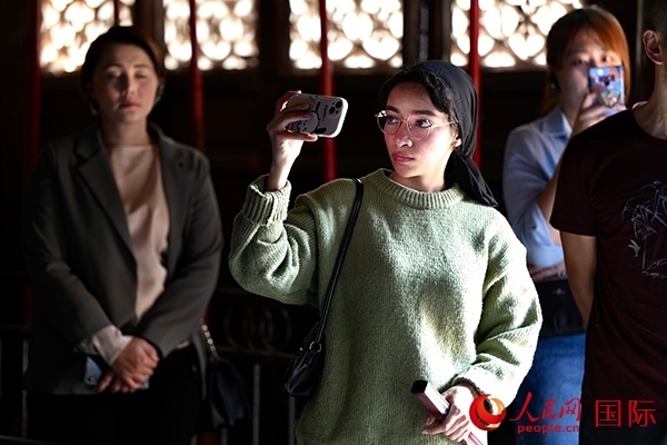 選手顏青（蘇丹）用手機記錄所見所感。人民網(wǎng) 盧鵬宇攝