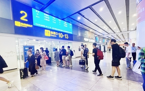 在快速進站廳前排隊等待檢票的旅客。人民網(wǎng)記者 喬雪峰攝