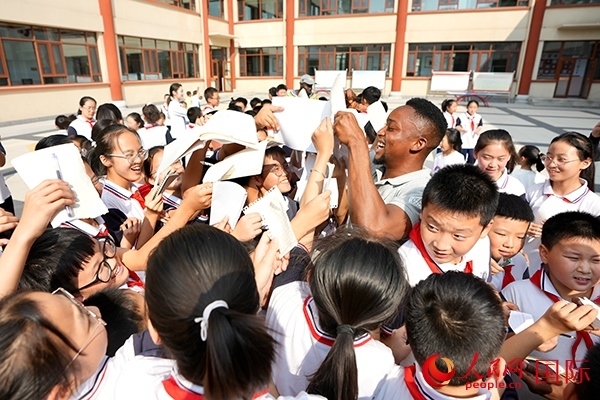 孩子們和選手互動(dòng)簽名。人民網(wǎng) 盧鵬宇攝