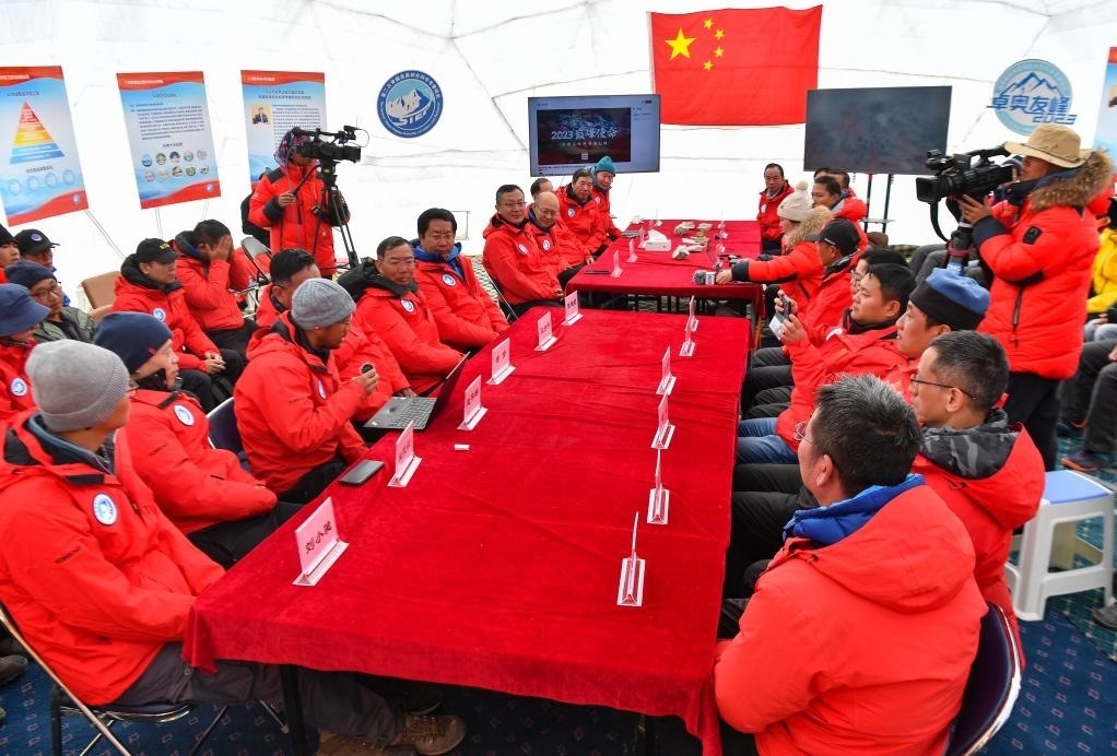 海拔4950米的卓奧友峰科考大本營，科考隊員趙華標（手拿麥克風看電腦者）在宣讀剛剛接收到的頂峰氣象觀測數(shù)據(jù)，這標志著峰頂自動氣象站架設成功，成功傳回觀測數(shù)據(jù)（10月1日攝）。新華社記者晉美多吉 攝
