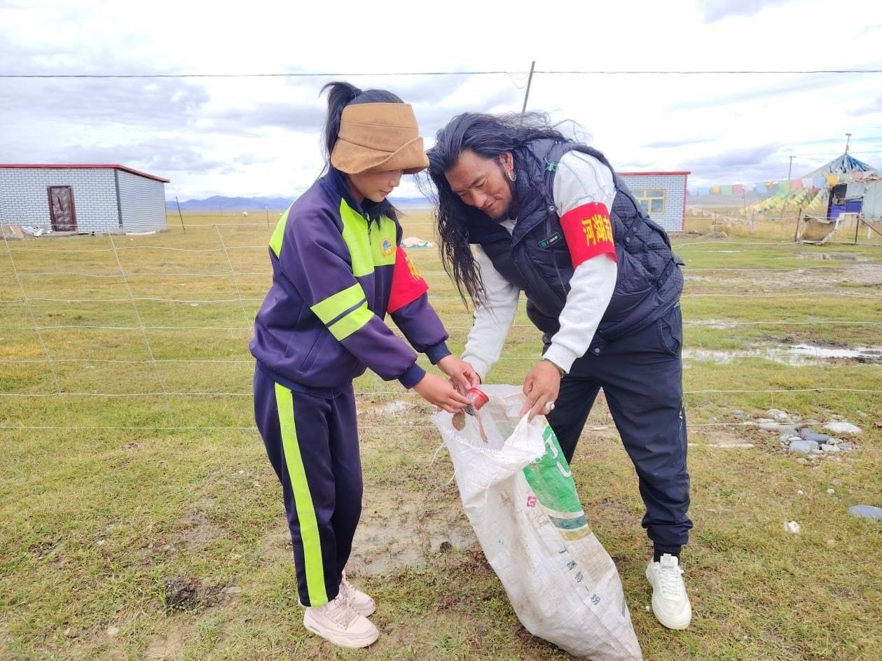 玉樹州稱多縣珍秦鎮(zhèn)河湖志愿者才培和他女兒更求拉毛在清掃垃圾。受訪者供圖