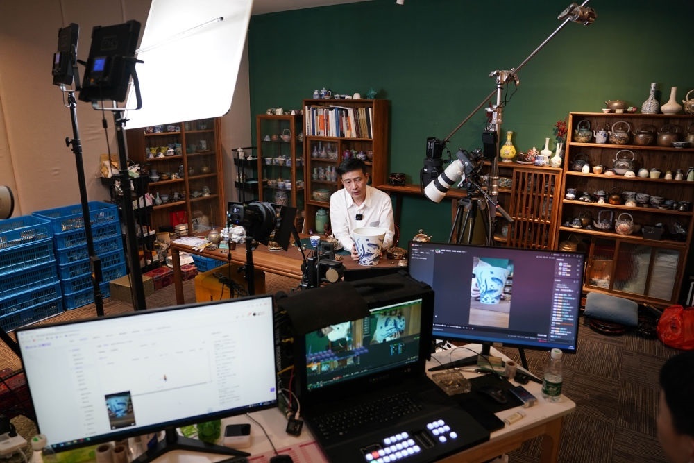 ↑在景德鎮(zhèn)，工作人員通過(guò)網(wǎng)絡(luò)直播推介陶瓷產(chǎn)品（2023年2月22日攝）。