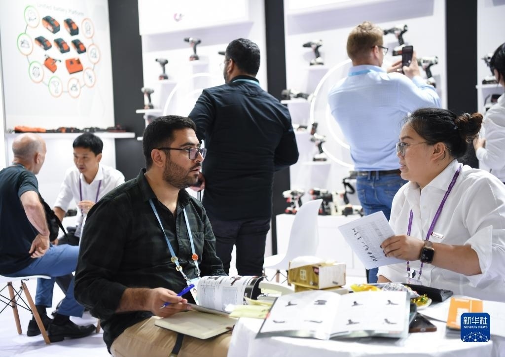 10月15日，在一家電動工具展臺，外國采購商在洽談業(yè)務(wù)。新華社記者 鄧華 攝