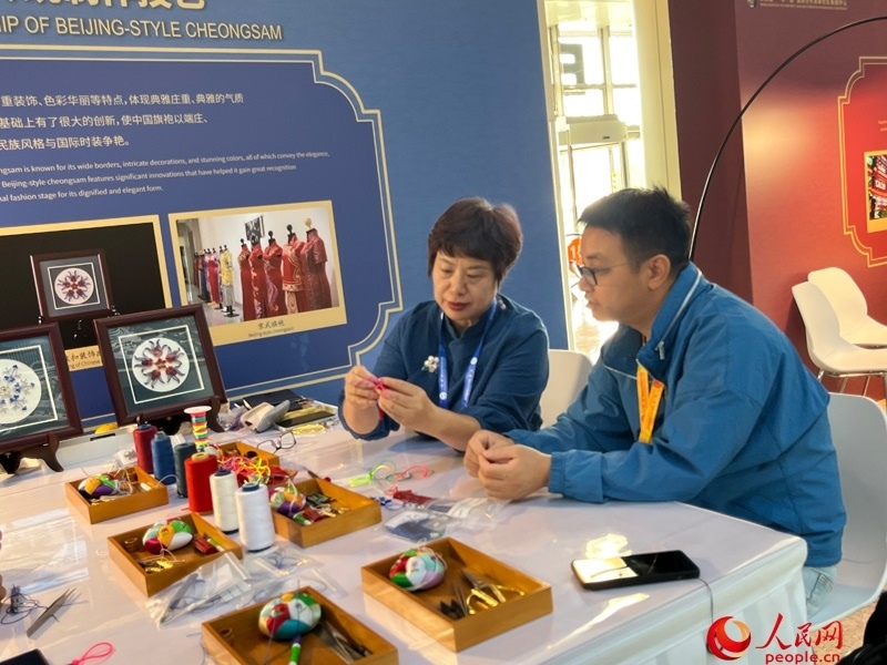 記者在新聞中心非遺傳承人展區(qū)進行體驗。人民網(wǎng)記者 杜燕飛攝