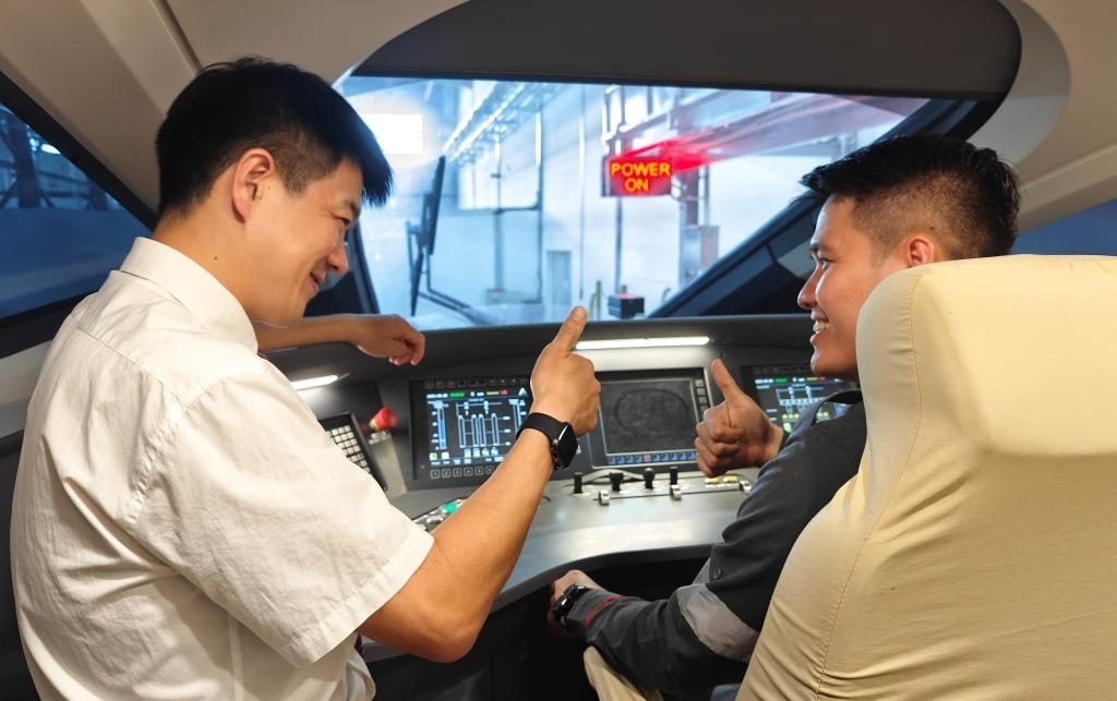 8月25日，在印度尼西亞萬隆的雅萬高鐵德卡魯爾動(dòng)車所內(nèi)，中國師傅穆振（左）在向印尼火車司機(jī)塞蒂亞萬講解動(dòng)車組出庫前的上電作業(yè)。