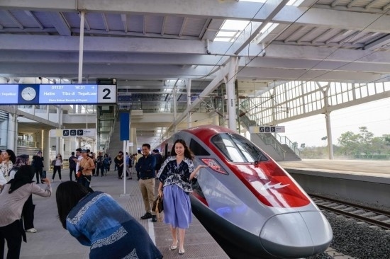  10月17日，在印度尼西亞萬隆德卡魯爾站，乘客在站臺上和雅萬高鐵高速動車組列車合影。新華社記者 徐欽 攝