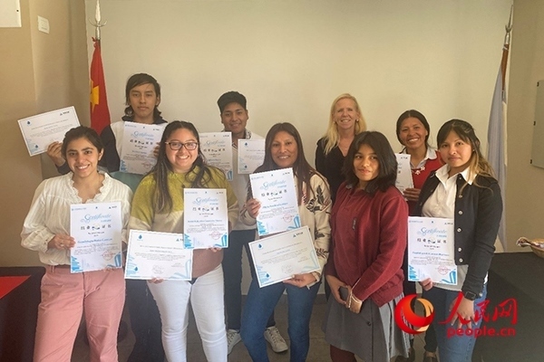 社區(qū)工作專家莫伊拉（后排右二）向“中文工坊”第二期培訓(xùn)班部分結(jié)業(yè)學(xué)員頒發(fā)由薩爾塔省教育部簽發(fā)的結(jié)業(yè)證書。人民網(wǎng)記者 吳思萱攝