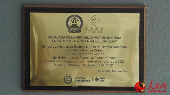 小學墻上懸掛的中國援助標識。人民網(wǎng)記者 張若涵攝