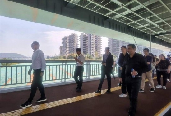 10月24日，2023“一帶一路”媒體合作論壇聯(lián)合采訪團團員走在清水塘大橋景觀通道上。本報記者 常雯宜攝