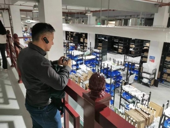 2023“一帶一路”媒體合作論壇聯(lián)合采訪團(tuán)團(tuán)員在仁和醫(yī)藥物流園拍攝記錄轉(zhuǎn)運(yùn)流程。（本報(bào)記者 黃超攝）