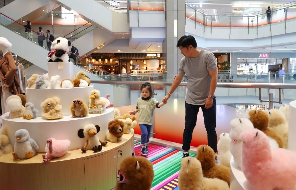 2023年11月2日，顧客在溫暖駝品牌專柜內(nèi)選購。連續(xù)六年參加進(jìn)博會(huì)的秘魯羊駝制品品牌溫暖駝在上海市中心商場(chǎng)開設(shè)了專柜。新華社記者 方喆 攝