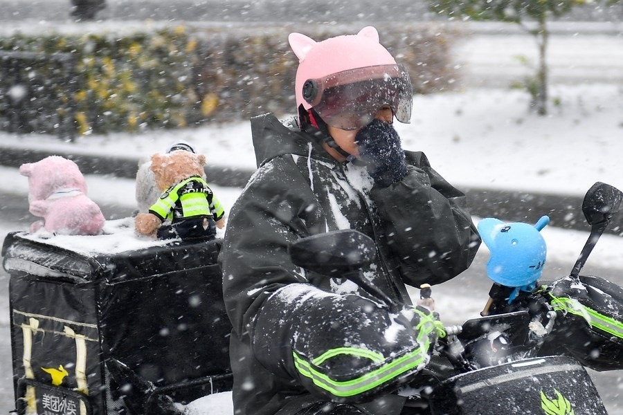 11月6日，在長春市街頭，一名外賣員在雪中騎行。新華社記者 許暢 攝